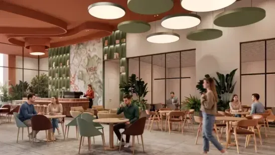 coworking The coworking lounge, with round ceiling discs in cream, olive and terracotta above small tables where people are working on laptops